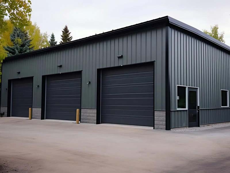 Dark grey industrial-grade metal garage featuring three roll-up doors and side windows.