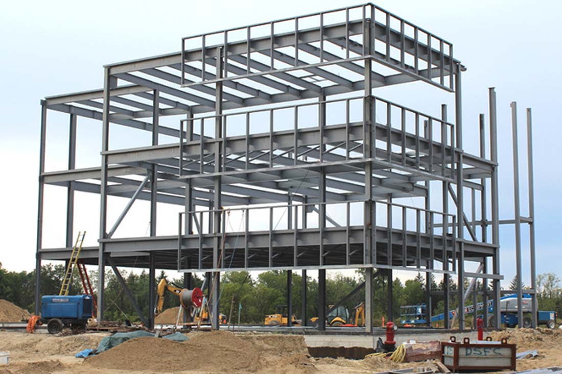 Multi storey steel building frame under construction, showing three-level steel columns and beams with open floor framing for commercial or industrial use.