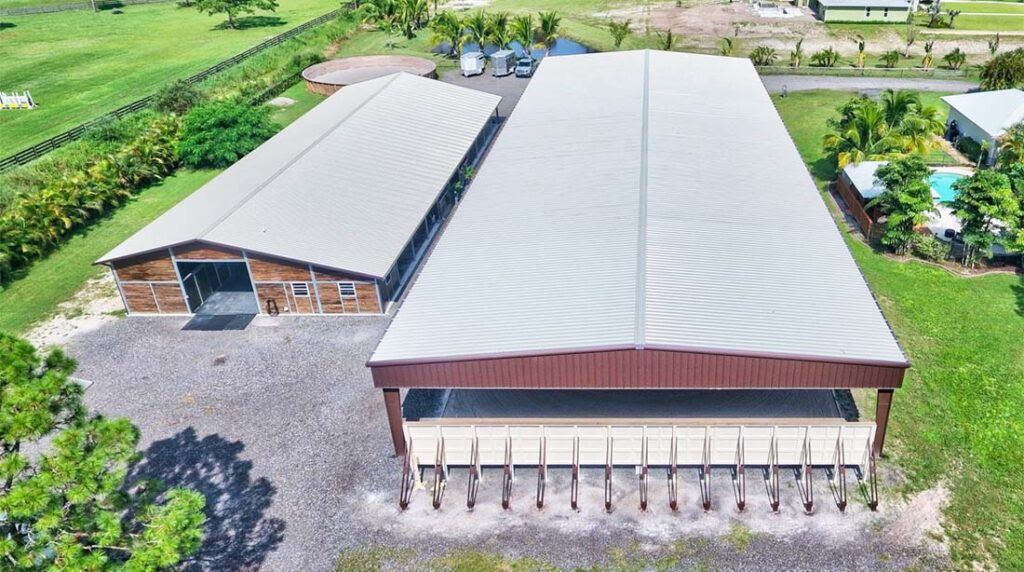 Aerial view of a large indoor riding arena building with long-span roof for all-weather equestrian use