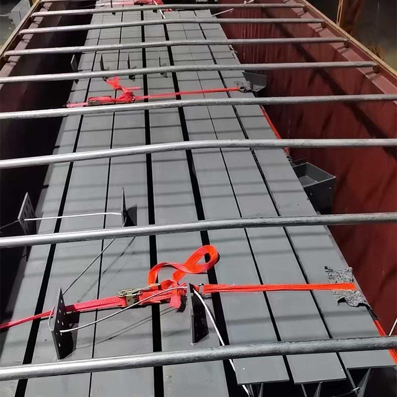 Steel members secured with lashing straps inside a container to prevent movement during shipping