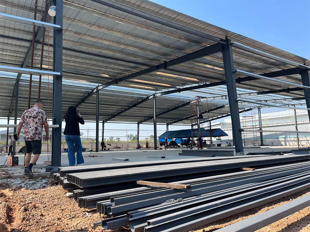 Steel members staged on site during installation of a 50m × 40m × 6m steel structure building in Thailand