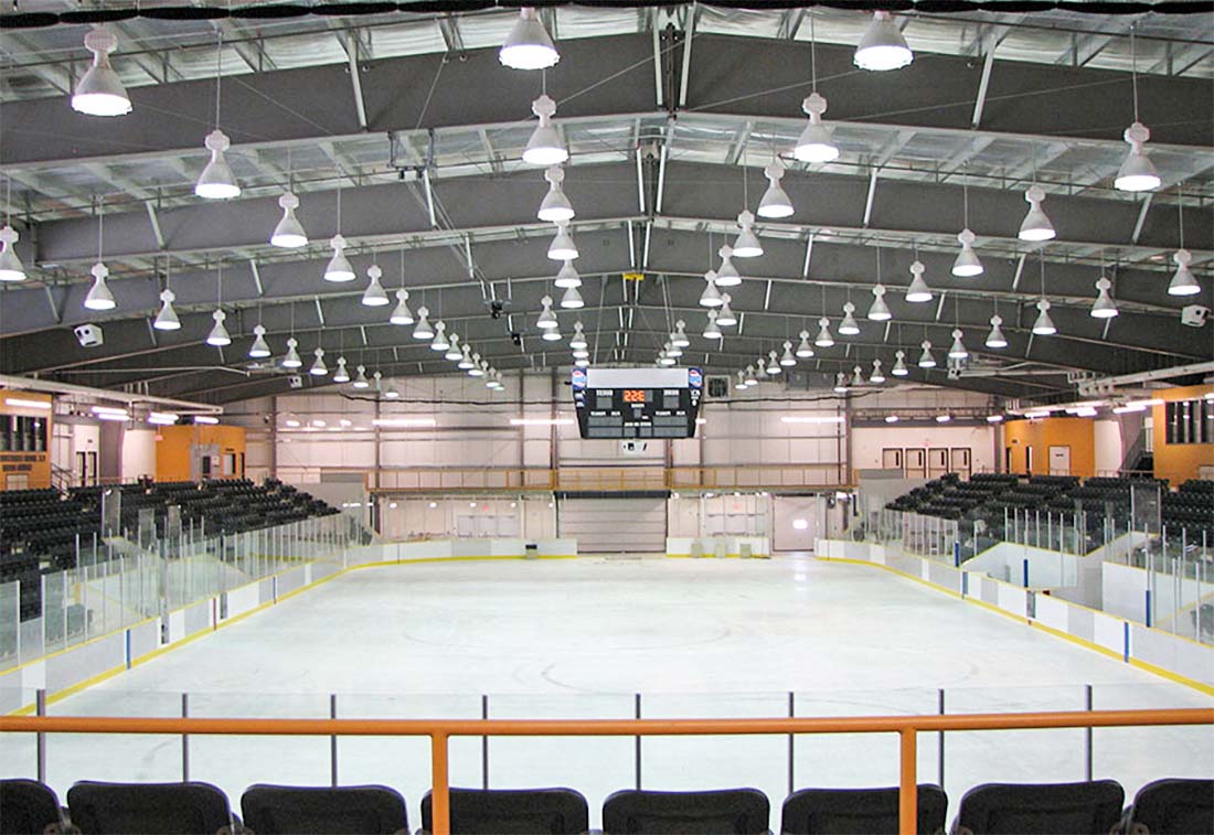Prefab steel sports arena featuring an ice hockey rink, spectator stands, and a clear-span roof structure