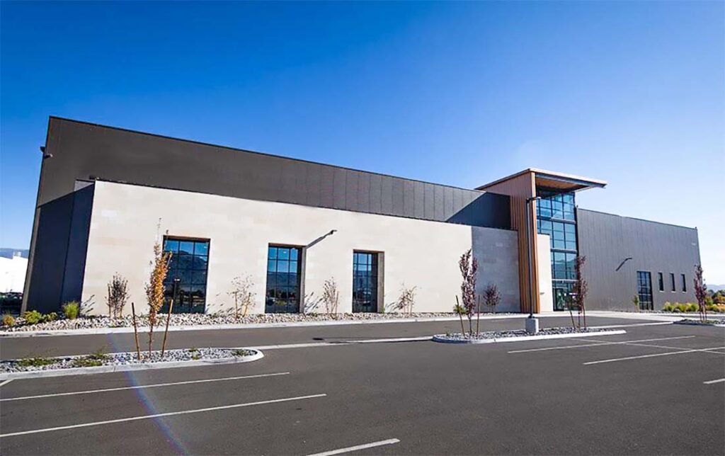 Exterior view of a prefabricated steel building gymnasium with insulated wall panels and large entrance doors