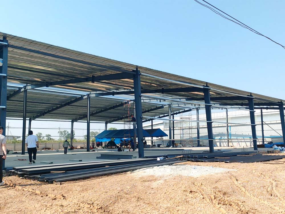 Steel portal frames and roof members being installed for a 50m × 40m steel building in Thailand