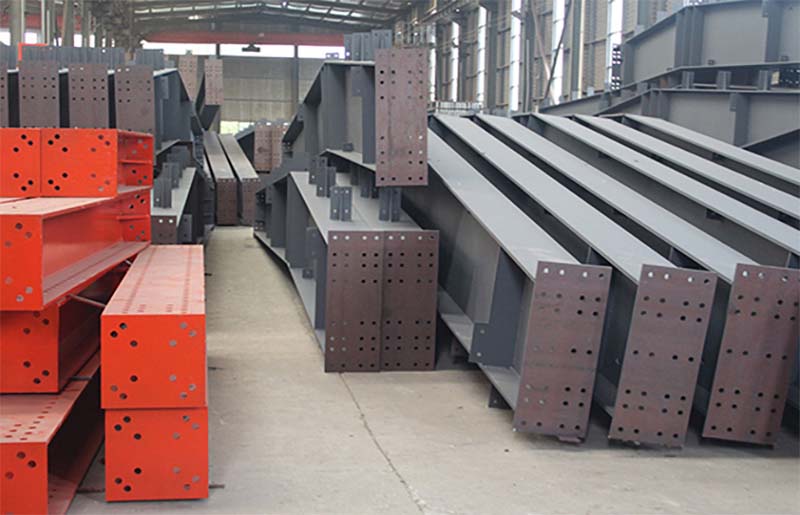 Steel beams and components stacked neatly.