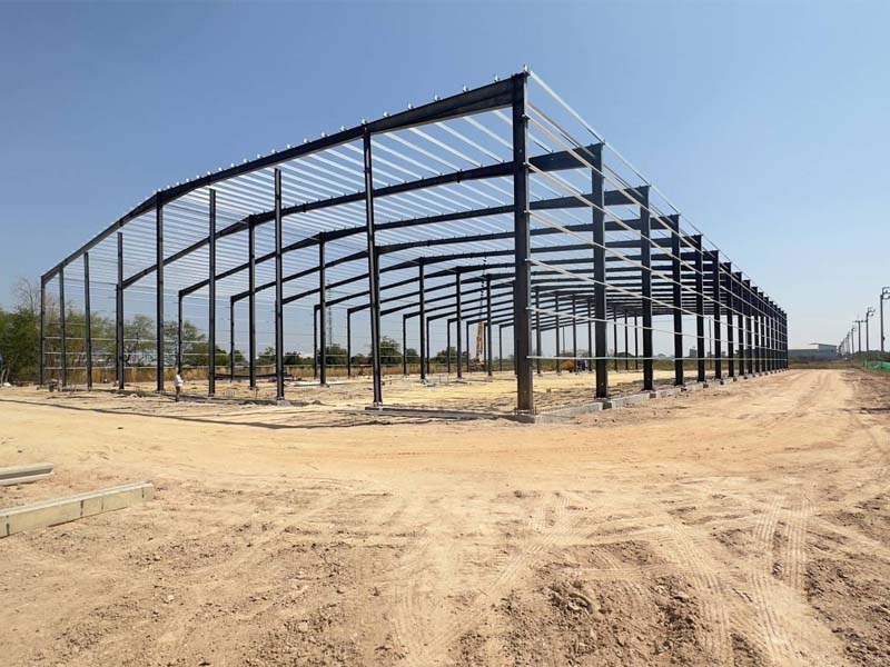 Exterior view of a large steel frame building under erection in Thailand, supplied as prefabricated steel structure