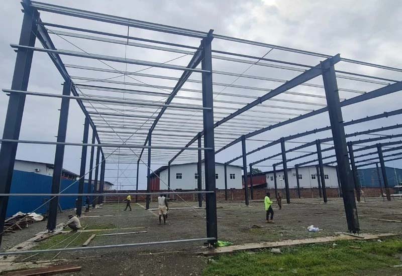 Interior view showing steel portal frame alignment during warehouse erection, Solomon Islands