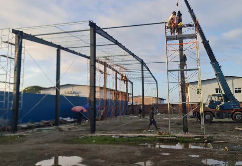 On-site installation work with lifting equipment during steel warehouse construction, Solomon Islands