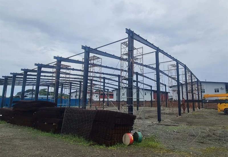 Steel structure warehouse frame under construction with portal frames and scaffolding on site in the Solomon Islands (40m × 60m × 7.5m)