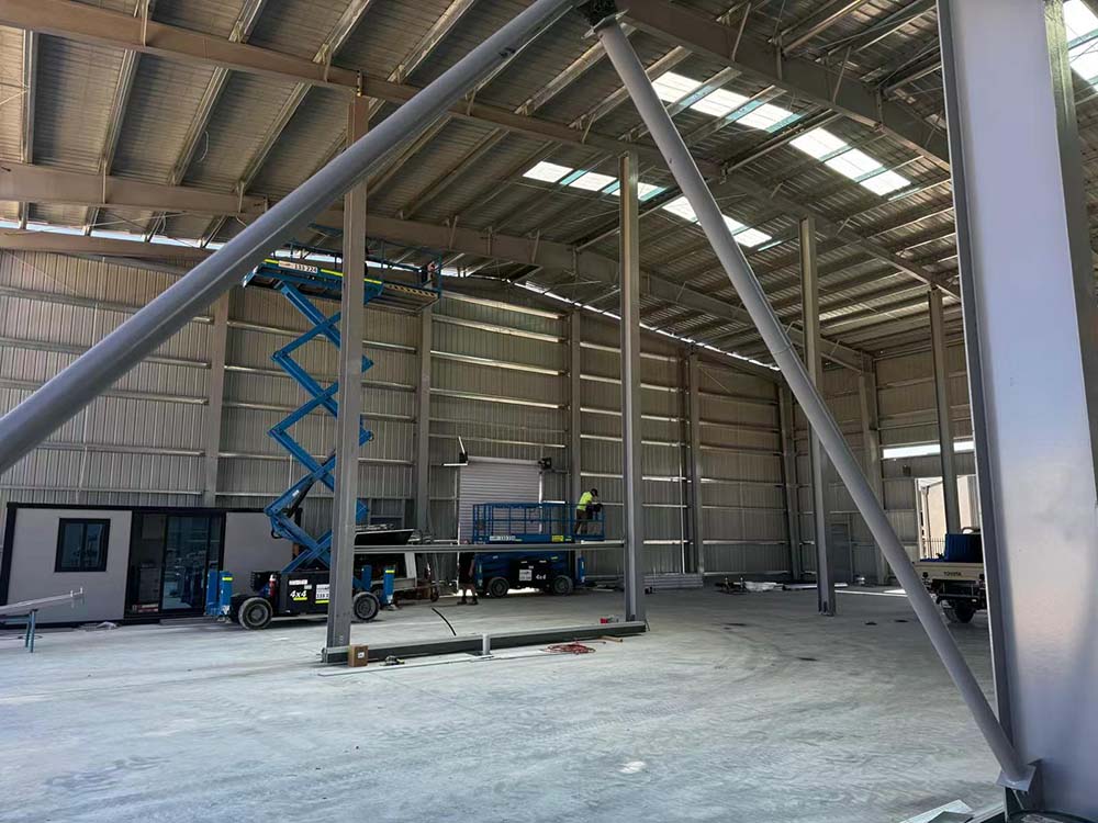Close-up of steel frame bracing and column connections inside the 25m × 50m × 8m steel workshop building in Australia.
